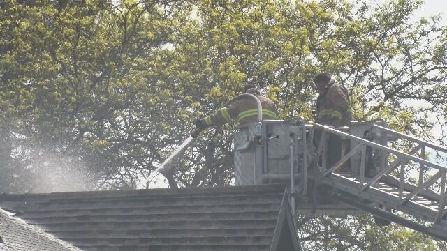 firefighters using hose on roof